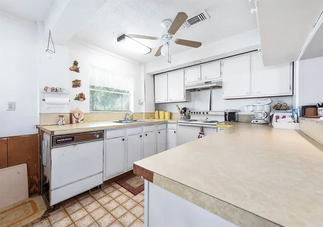a kitchen that has a sink and a stove in it