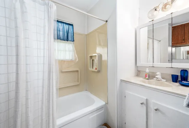 a bedroom with a bed dresser and a window