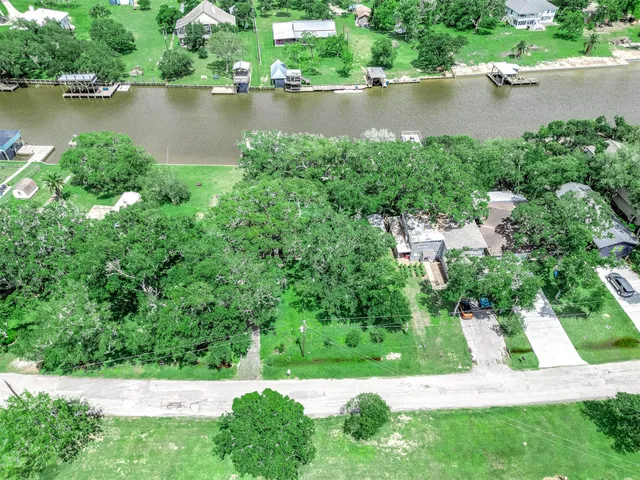 an aerial view of residential house with outdoor space and trees all around