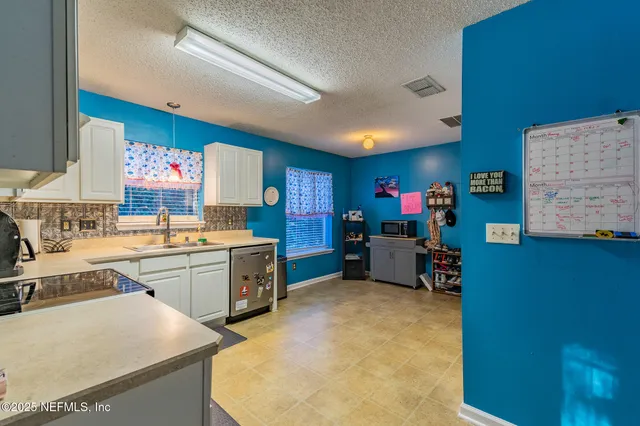 a kitchen with granite countertop a stove sink and cabinets