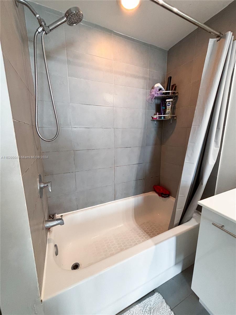 92 Southwest 3rd Street, Unit 4407 Miami, FL 33130 - Photo 14 of 21 a bathroom with a tub a sink and glass door