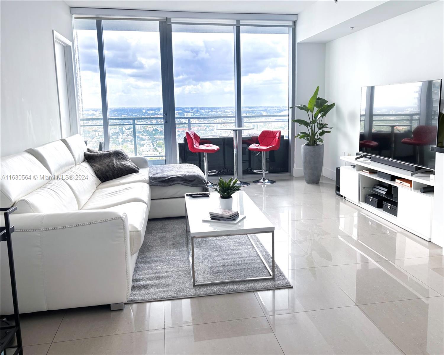 92 Southwest 3rd Street, Unit 4407 Miami, FL 33130 - Photo 2 of 21 a living room with furniture large window and a flat screen tv
