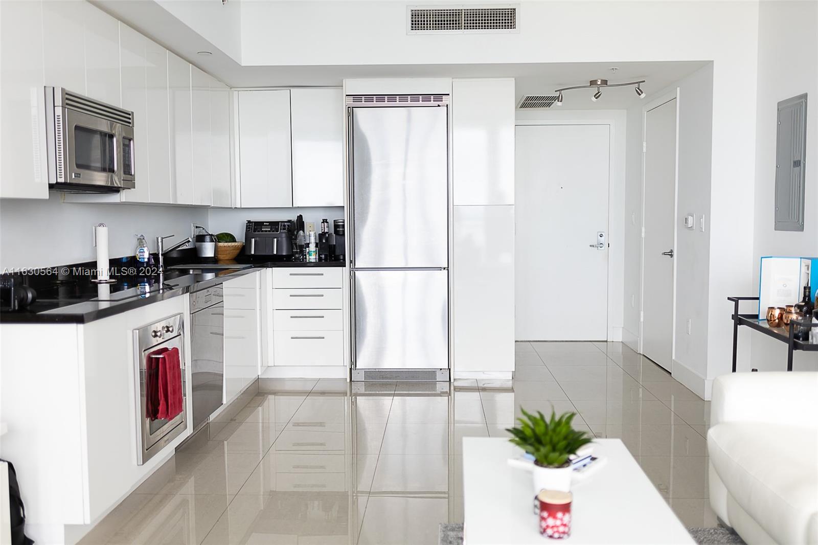 92 Southwest 3rd Street, Unit 4407 Miami, FL 33130 - Photo 4 of 21 a kitchen with granite countertop white cabinets and white appliances