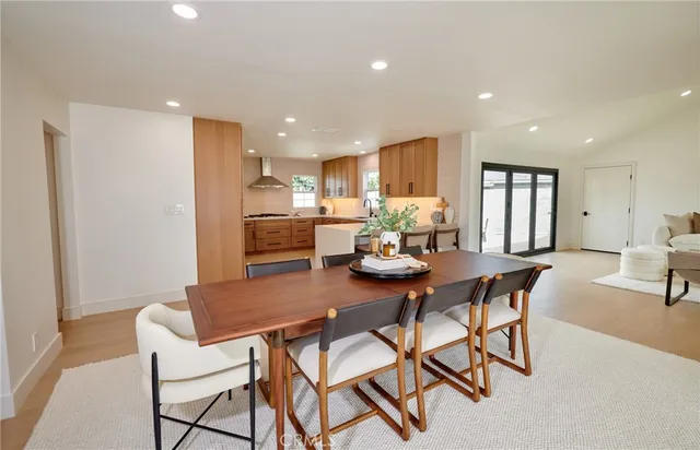 a kitchen with a dining table chairs and refrigerator