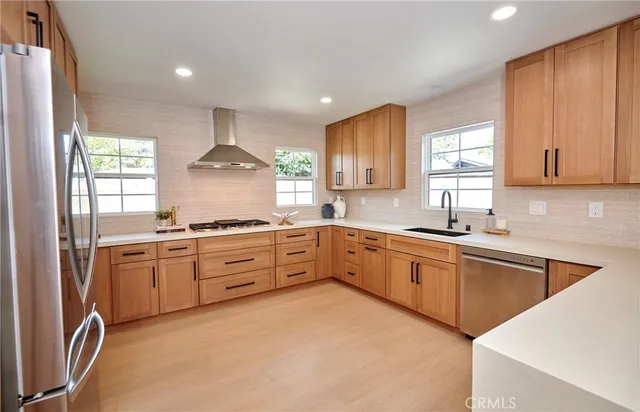 a kitchen with stainless steel appliances granite countertop a stove a sink and a refrigerator