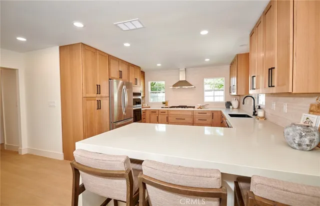 a kitchen with refrigerator a sink and a stove