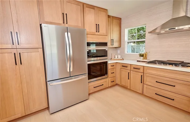 a kitchen with cabinets stainless steel appliances and window