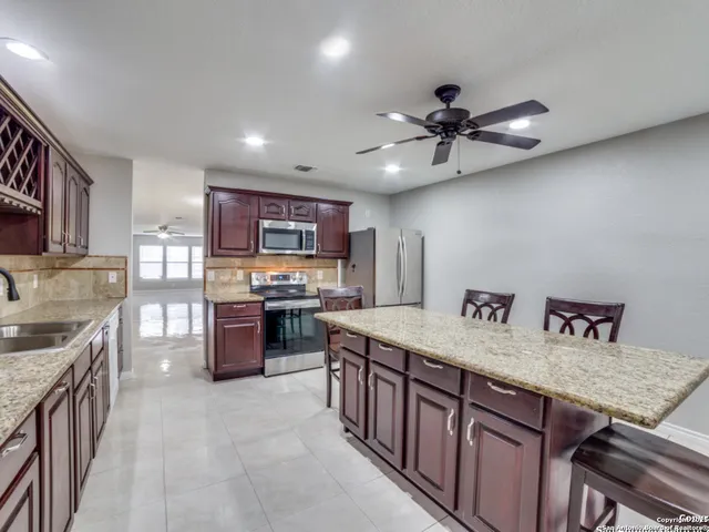 a kitchen with stainless steel appliances granite countertop a sink stove and refrigerator