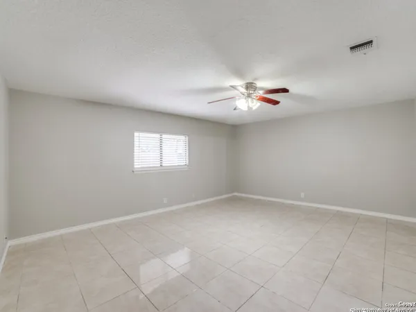 an empty room with windows and ceiling fan view
