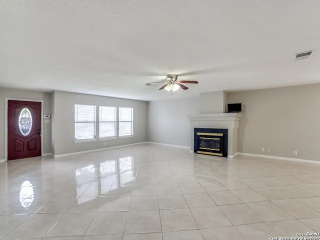an empty room with windows and fireplace
