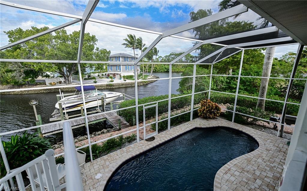 3858 Riviera Circle Bonita Springs, FL 34134 - Photo 22 of 34 a view of a chair and table in the backyard