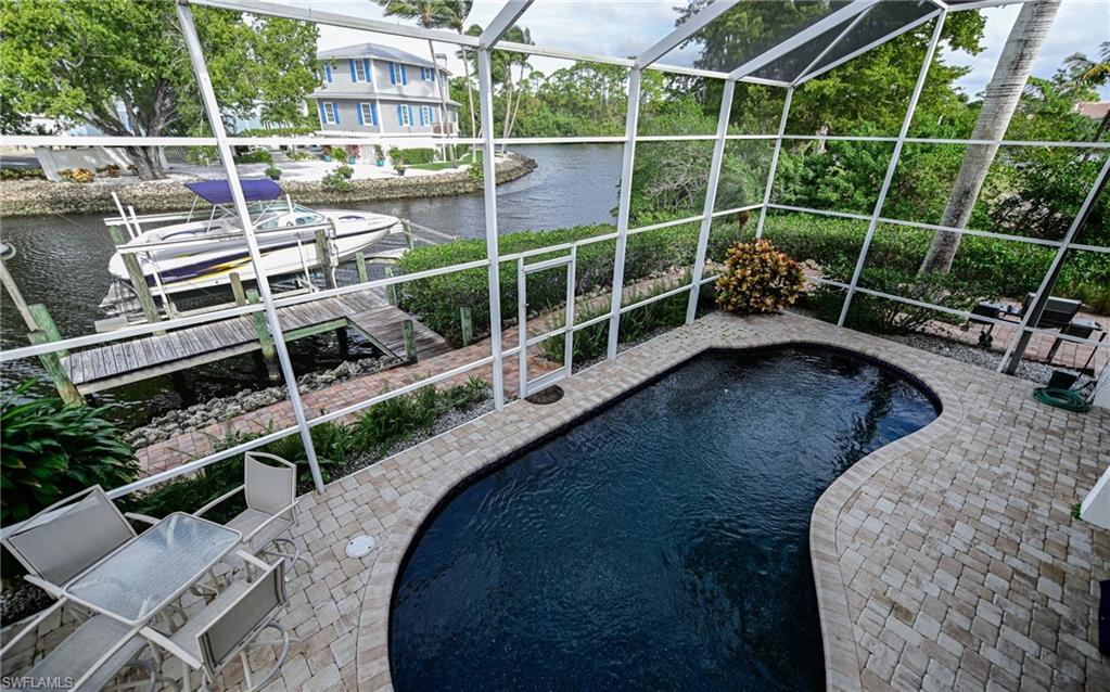 3858 Riviera Circle Bonita Springs, FL 34134 - Photo 24 of 34 a view of a chair and table in the backyard