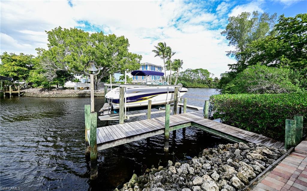 3858 Riviera Circle Bonita Springs, FL 34134 - Photo 27 of 34 a view of a wooden chairs and table in a backyard