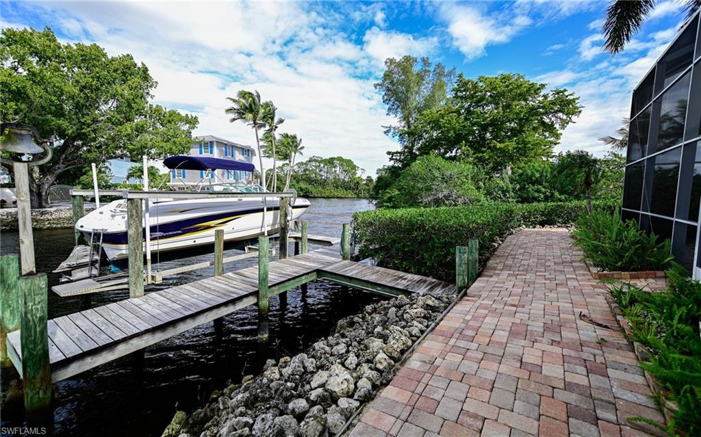 3858 Riviera Circle Bonita Springs, FL 34134 - Photo 28 of 34 a view of a chairs and table in the backyard