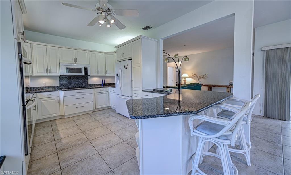 3858 Riviera Circle Bonita Springs, FL 34134 - Photo 7 of 34 a kitchen with granite countertop a sink stainless steel appliances and cabinets