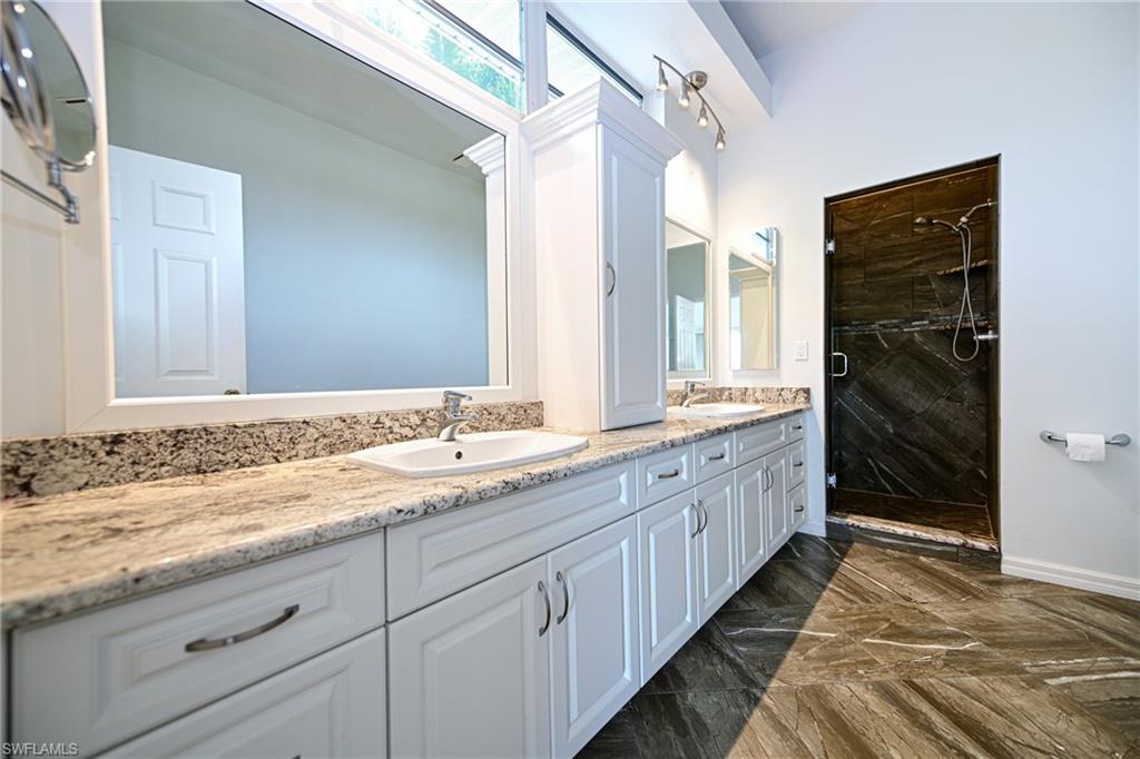 3858 Riviera Circle Bonita Springs, FL 34134 - Photo 10 of 34 a bathroom with a granite countertop sink and a large mirror