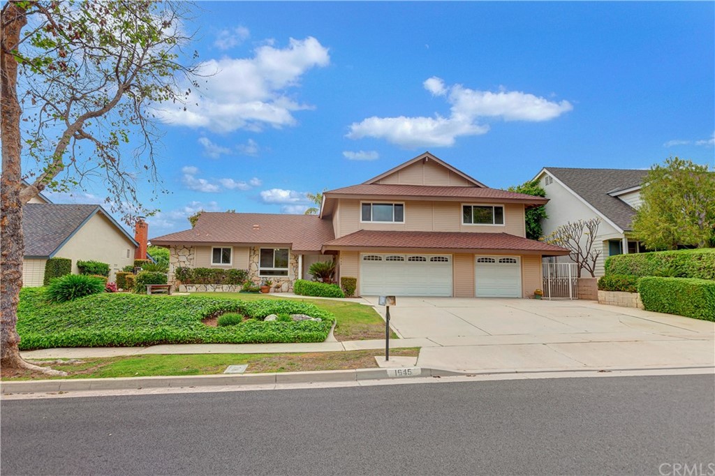 a view of house with a garden and pathway