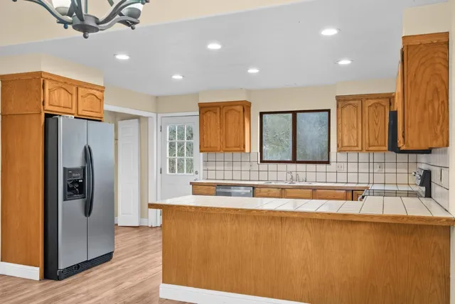 a kitchen with stainless steel appliances granite countertop a sink and a refrigerator