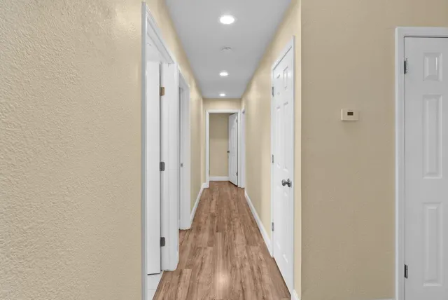 a view of a hallway with wooden floor and staircase