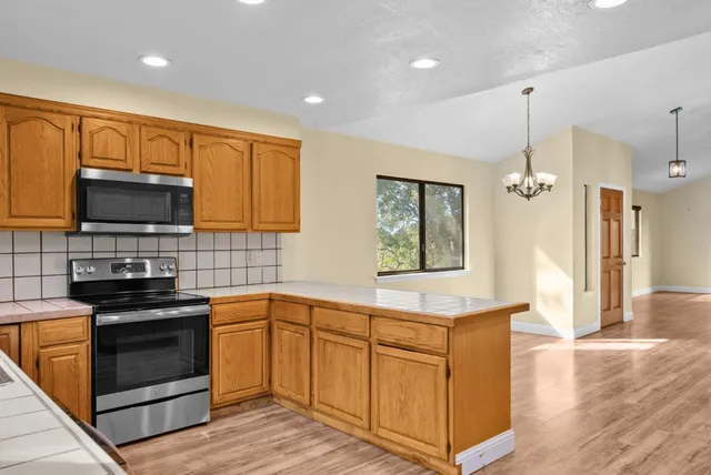 a kitchen with stainless steel appliances granite countertop a stove a sink and a microwave