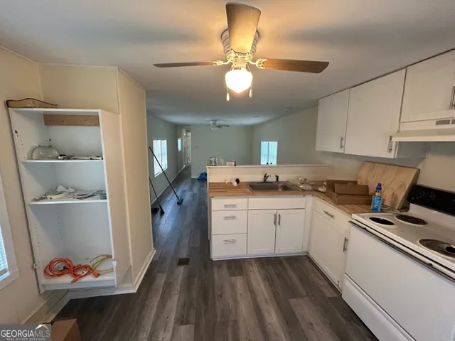 a kitchen with cabinets appliances and a ceiling fan