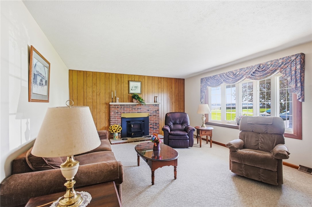 6718 Old Columbus Road South Vienna, OH 45369 - Photo 6 of 33 This inviting living room features a classic brick fireplace and a large bay window.