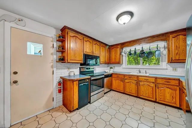 a kitchen with stainless steel appliances granite countertop a stove a sink and a microwave