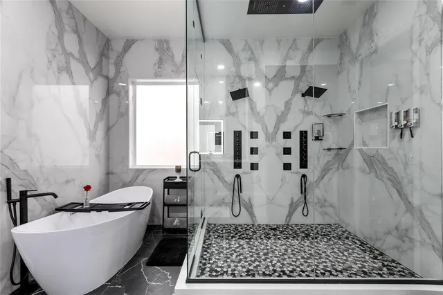 a large white tub sitting next to a white sink
