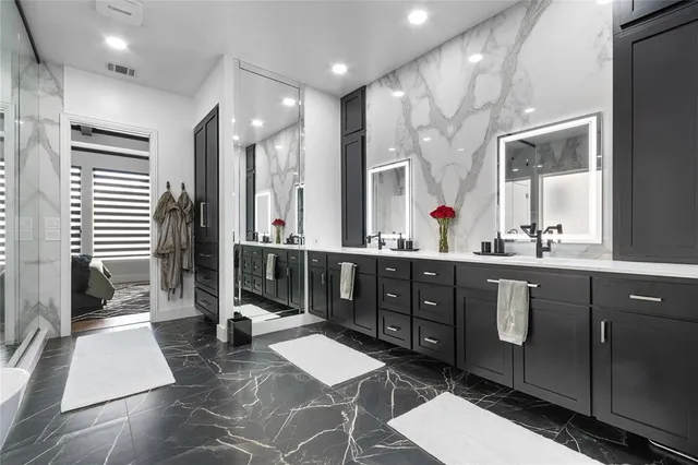 a spacious bathroom with a double vanity sink a mirror and a shower