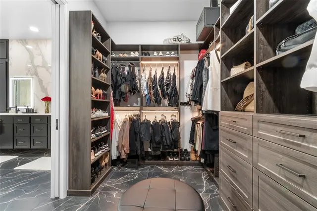 a view of walk in closet with clothes and shoes