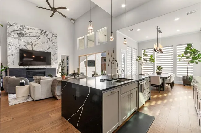 a kitchen with stainless steel appliances granite countertop a sink a stove and a wooden floors