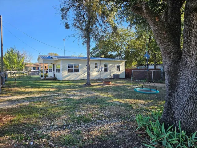 a view of a house with backyard and a tree