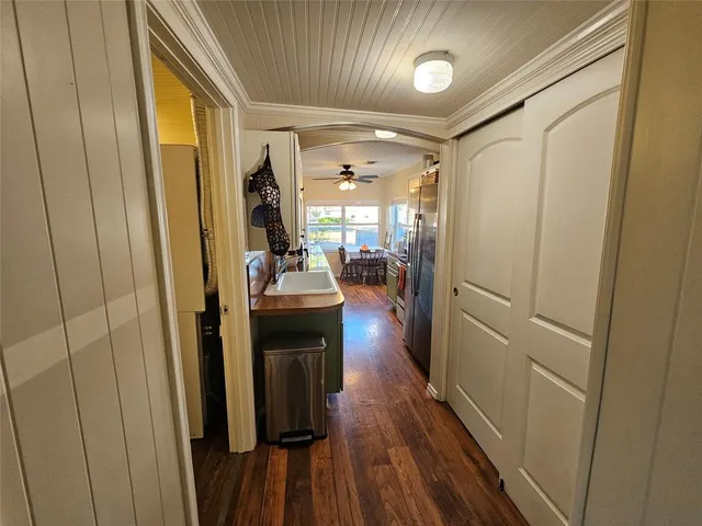 a view of a hallway and wooden floor with livingroom view