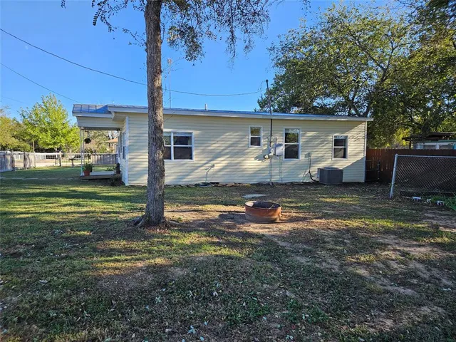 a backyard of a house with barbeque oven table and chairs