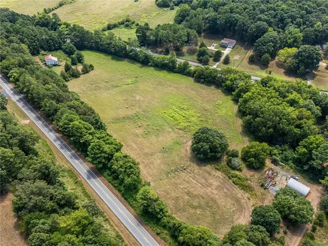 an aerial view of residential house with outdoor space and trees all around