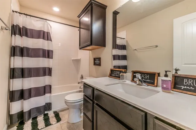 a bathroom with a sink a toilet a mirror and shower