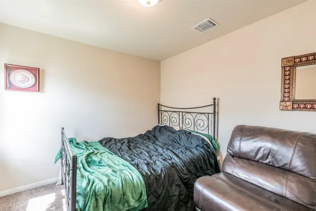 a bedroom with a bed next to a window with lamp