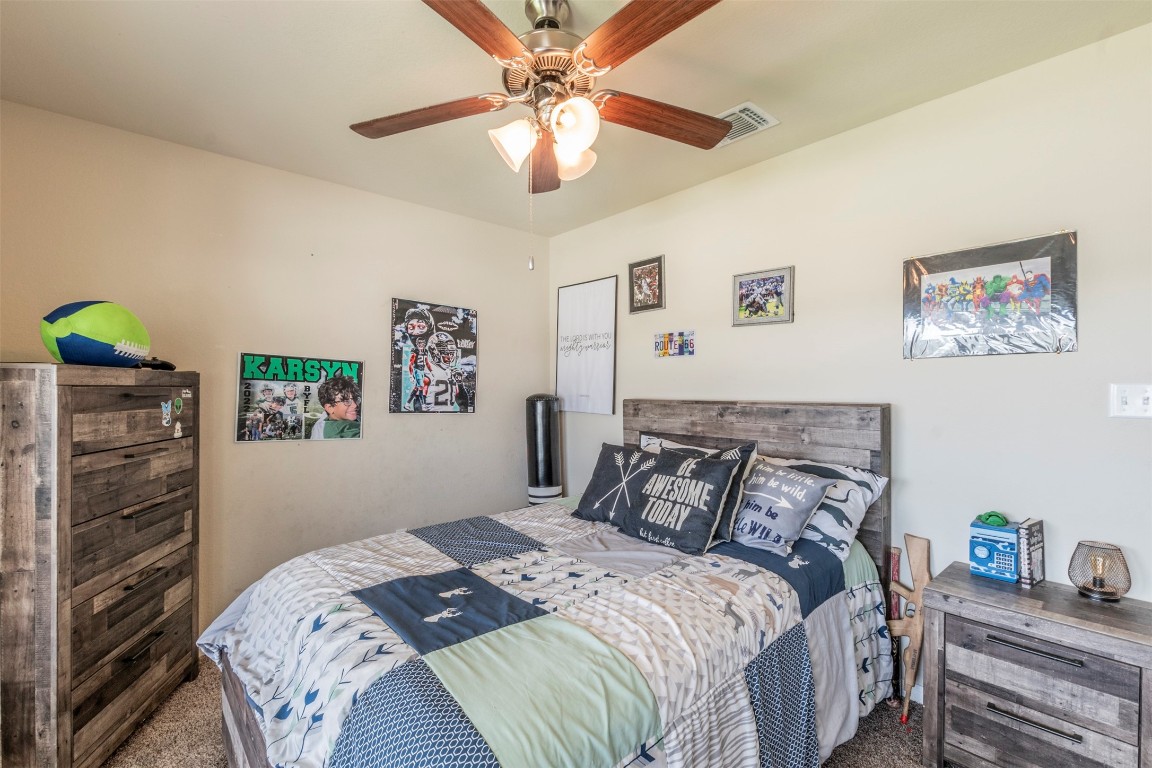 205 Pepper Mill Loop Burnet, TX 78611 - Photo 17 of 25 a bedroom with a bed and a chandelier