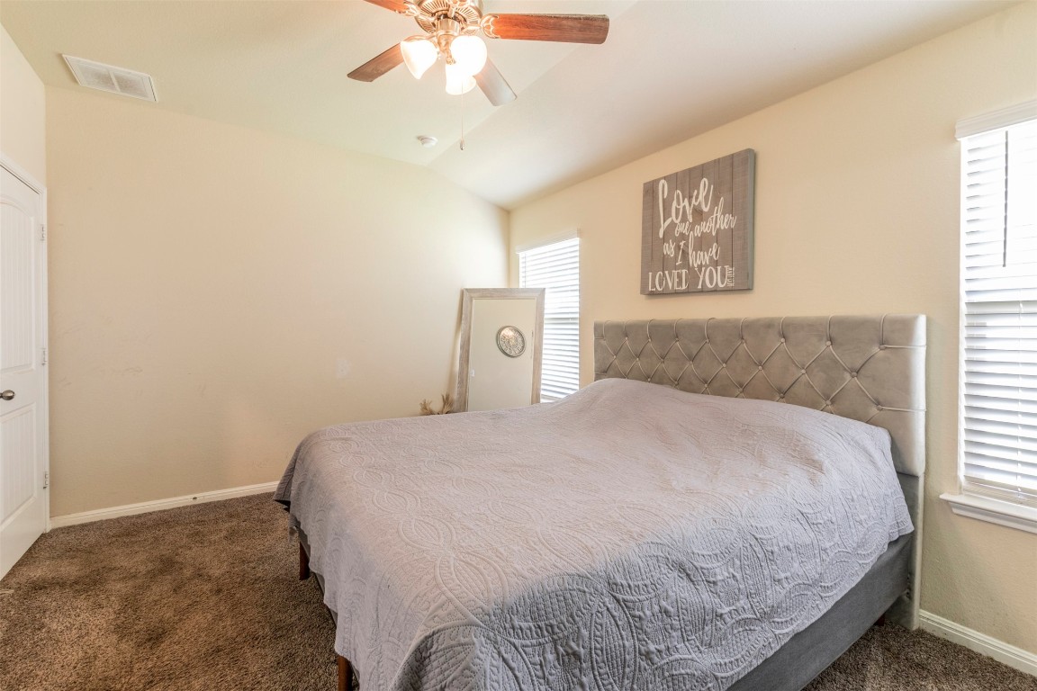 205 Pepper Mill Loop Burnet, TX 78611 - Photo 9 of 25 a bedroom with a bed and a chandelier