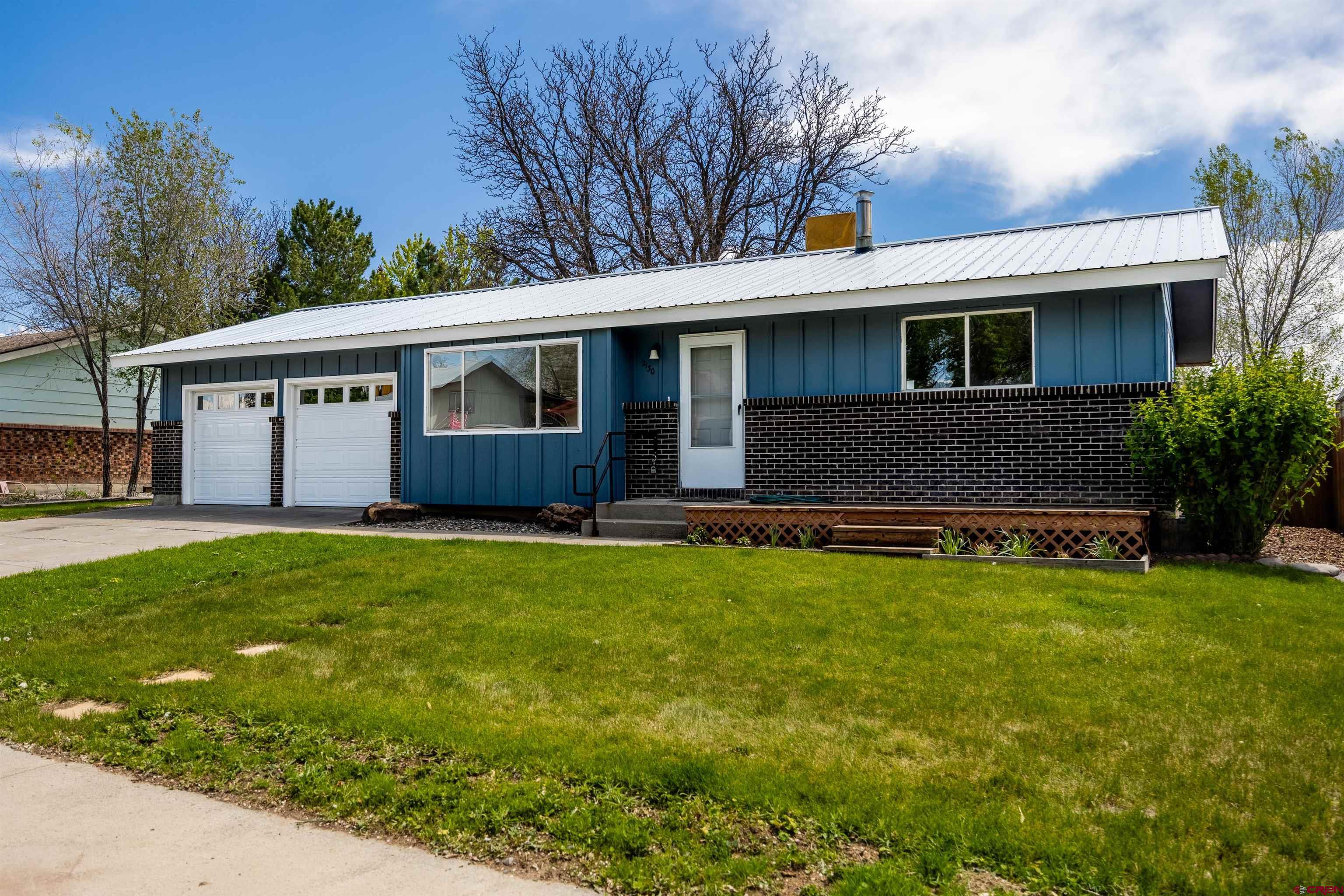 2130 Devon Street Montrose, CO 81401 - Photo 1 of 27 a front view of house with yard and trees in the background