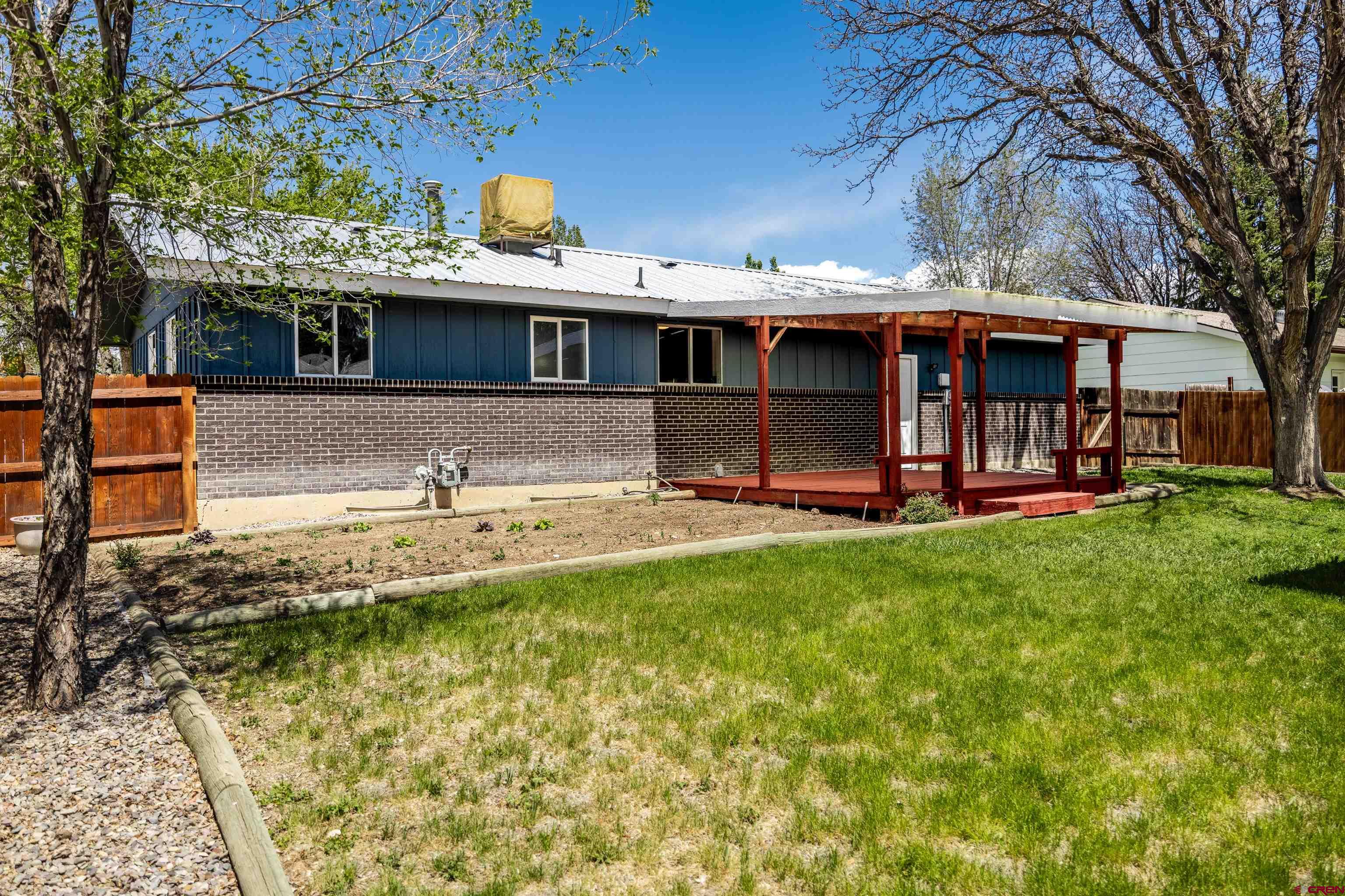 2130 Devon Street Montrose, CO 81401 - Photo 17 of 27 a view of a house with a backyard and a tree