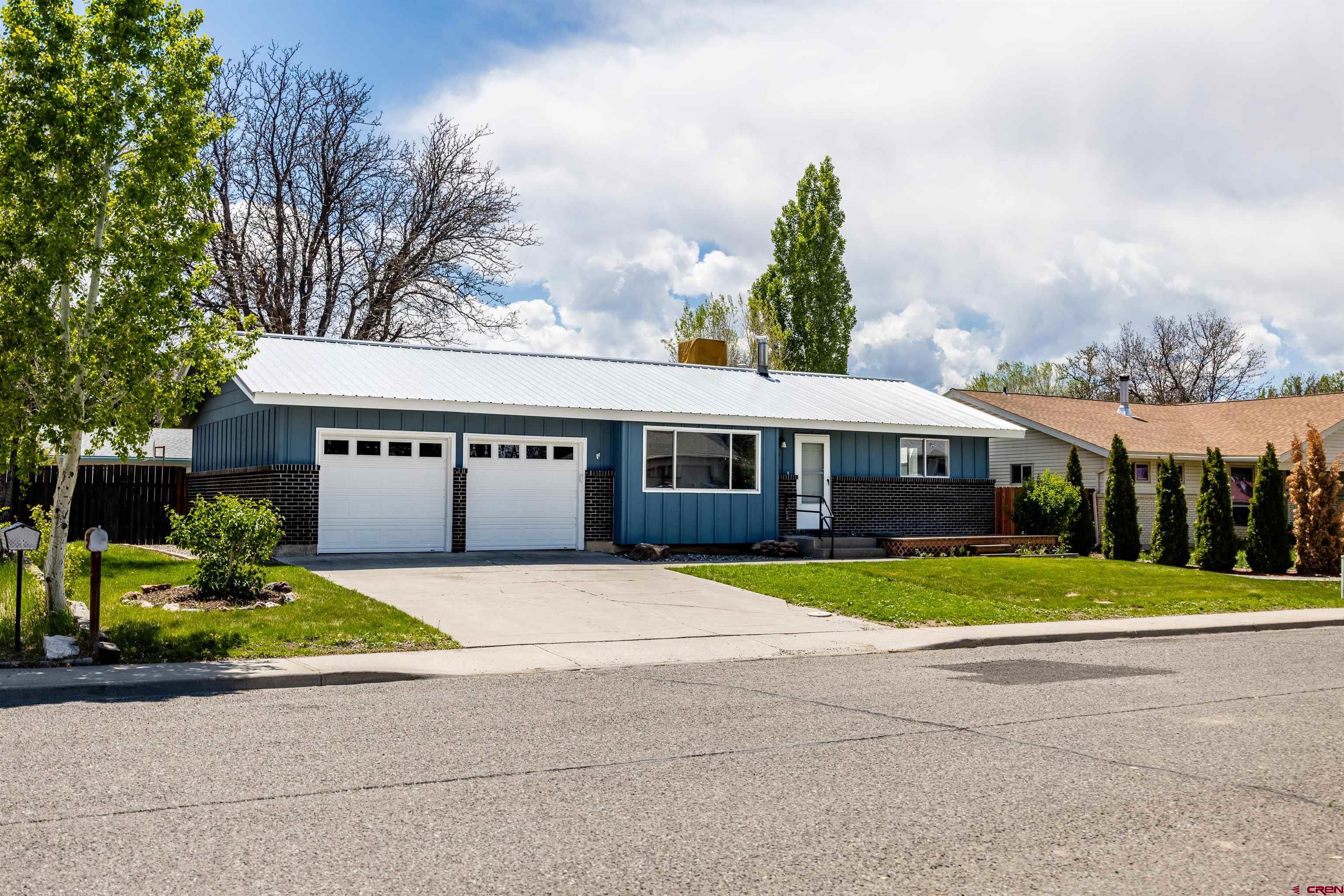 2130 Devon Street Montrose, CO 81401 - Photo 23 of 27 a front view of a house with a yard and trees