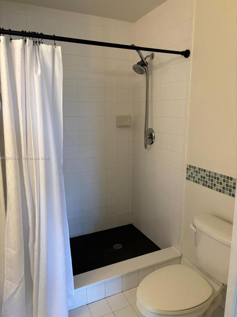 2081 Renaissance Boulevard, Unit 306 Miramar, FL 33025 - Photo 9 of 22 a bathroom with a shower a toilet and a shower curtain