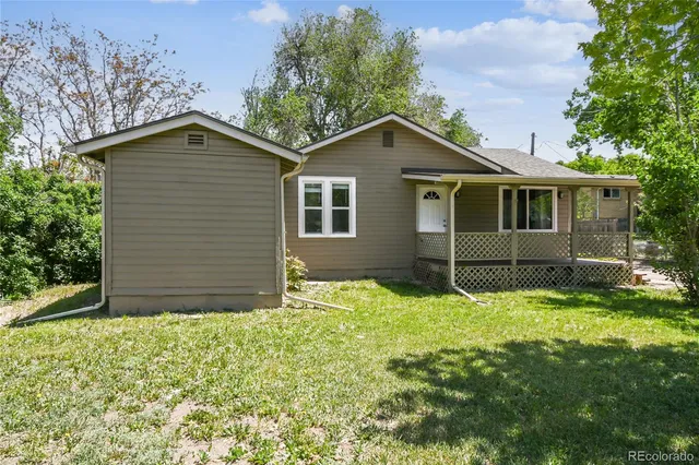 a view of a house with backyard and a tree