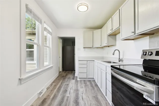 a kitchen with a stove and white cabinets