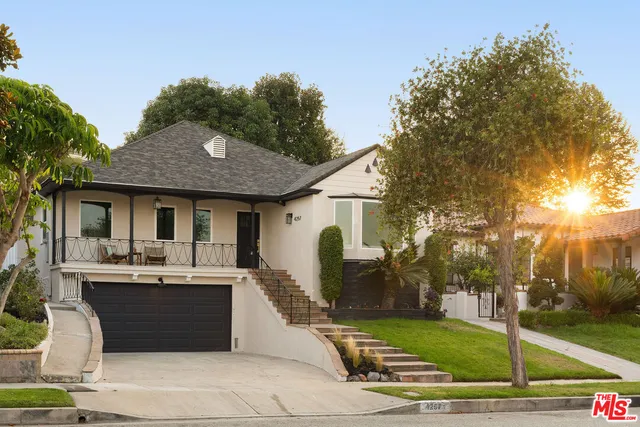 a view of a patio with couches and table and chairs with wooden fence and plants