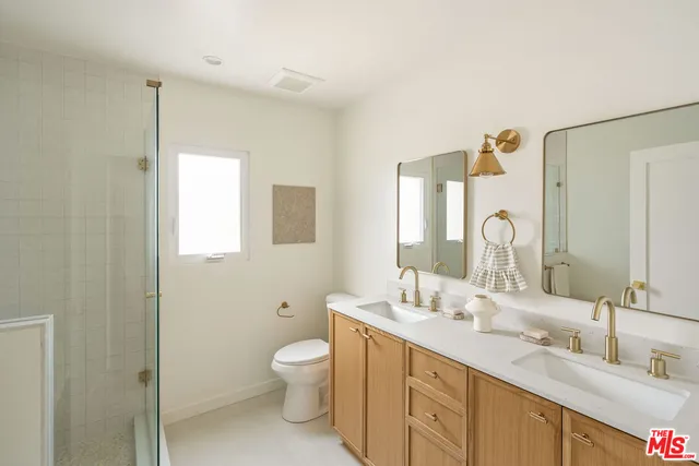 a bathroom with double vanity sinks and a mirror