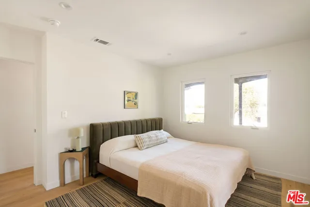 a bedroom with a bed and a painting on the wall