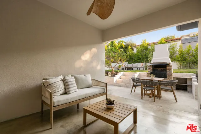 a table and chairs sitting in a backyard with large trees