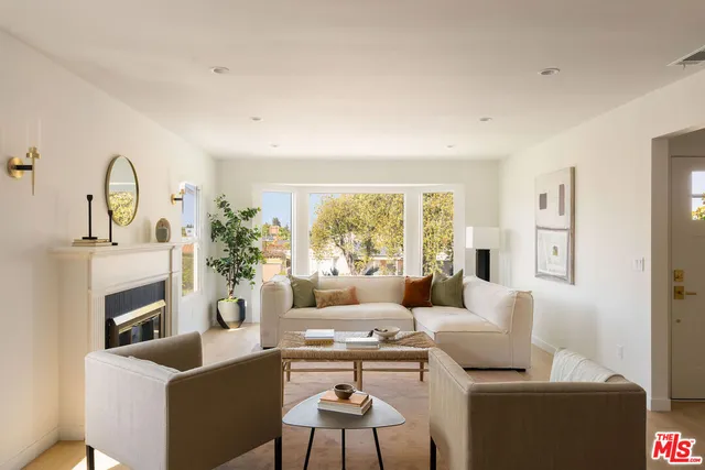 a living room with furniture a fireplace and a large window